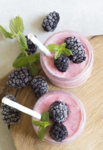 Two Very Berry Smoothies With Fresh Blueberries and Mint Garnishing Mason Jars Filled With Delicious Low Calorie Filling Desert Treats